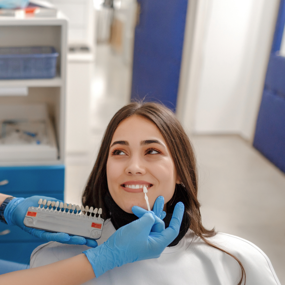 Women looks at Vietnamese dentist who is helping her choosing the perfect shade for her smile during smile design for Emax Porcelain Veneers. There are 16 shades. Emax porcelain veneers packages  in Vietnam are much more affordable than in Melbourne, Sydney, Perth, or Brisbane, Australia or even Thailand and Bali. Emax veneers are more premium than traditional veneer. They look translucent and mimic the colour of natural teeth. Glamjet offers 6 veneer, 10 veneer, 16 veneer packages