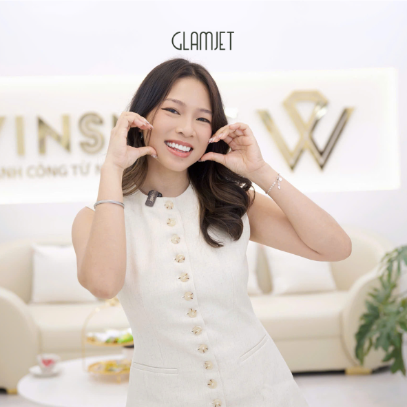 Woman in a white dress with gold buttons posing in a stylish room with 'GLAMJET' branding. She had Emax veneers smile makeover at a top tier dental clinic in Hanoi, Vietnam with Glamjet.com.au . She is a client from Australia originally came from the Phillipines