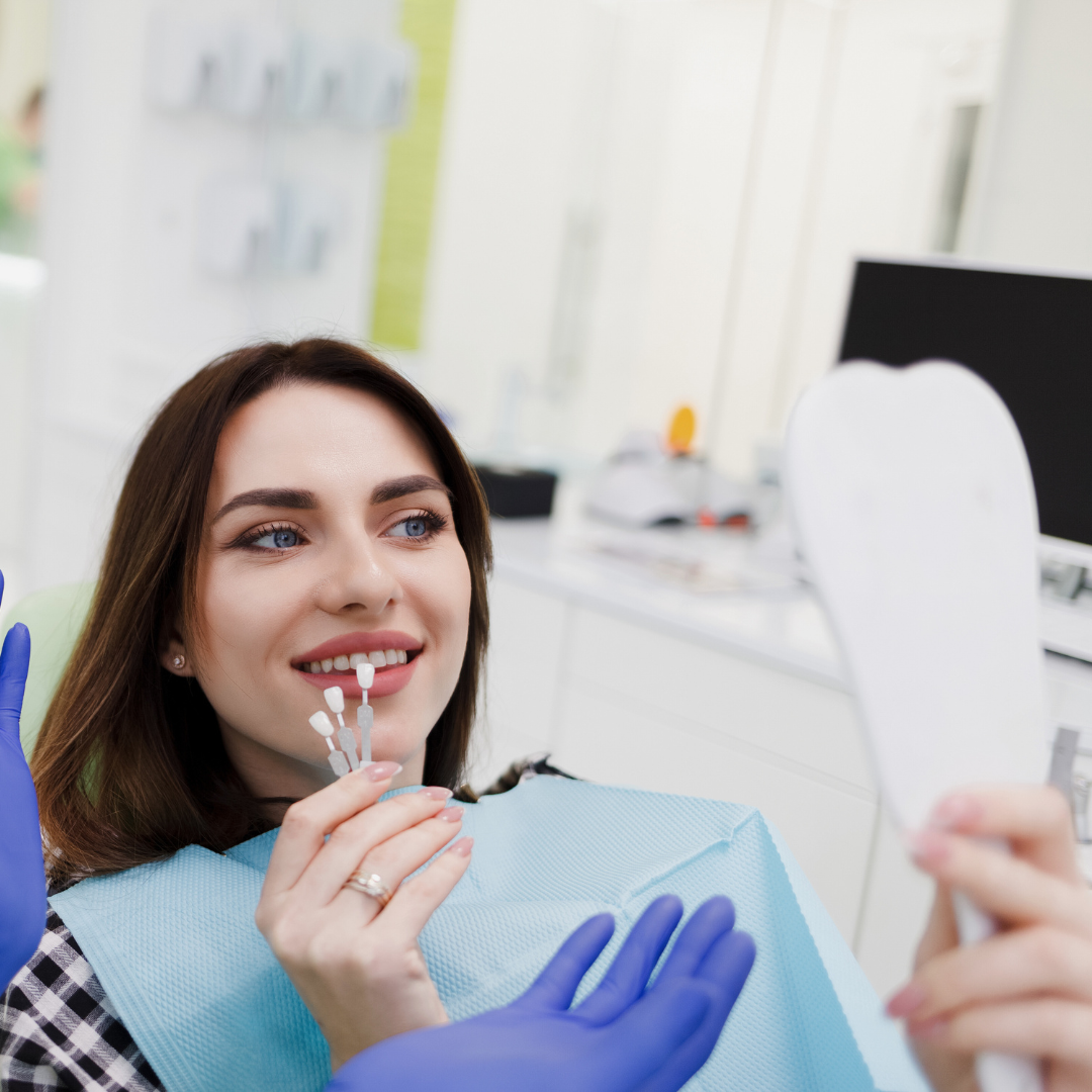 Women looks at Vietnamese dentist who is helping her choosing the perfect shade for her smile during smile design for Emax Porcelain Veneers. There are 16 shades. Emax porcelain veneers packages  in Vietnam are much more affordable than in Melbourne, Sydney, Perth, or Brisbane, Australia or even Thailand and Bali. Emax veneers are more premium than traditional veneer. They look translucent and mimic the colour of natural teeth. Glamjet offers 6 veneer, 10 veneer, 16 veneer packages 