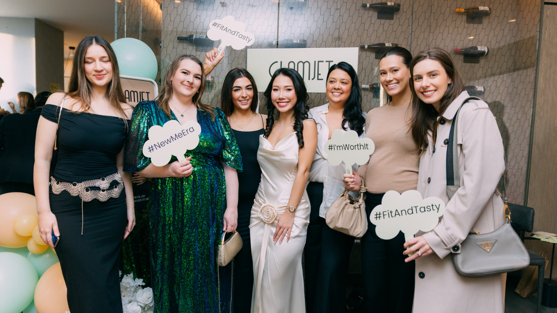 Group of women posing together with branded signs in a formal setting at Glamjet.com.au appreciation event. Glamjet is a leading beauty and medical tourism booking platform presented exciting news about partnerships with leading hospitals, clinics in South korea, Vietnam, Thailand, and Japan
