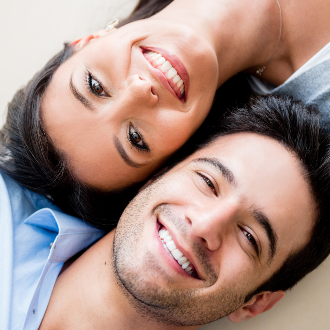 Couple smile happily after smile makeover at a leading dental clinic in Seoul, South Korea with porcelain veneers, zirconia crowns, and dental implants.