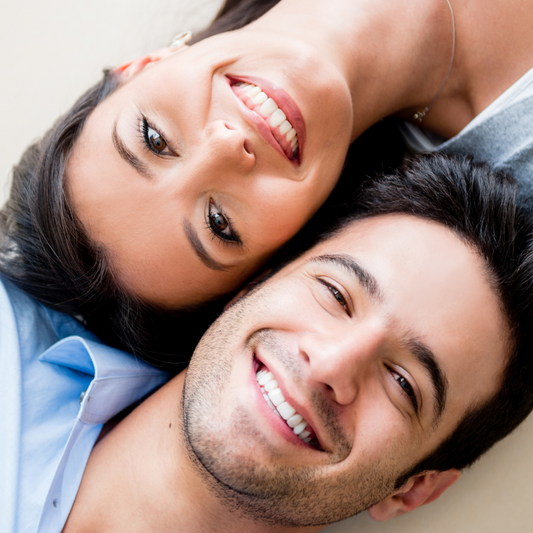 Couple smile happily after smile makeover at a leading dental clinic in Seoul, South Korea with porcelain veneers, zirconia crowns, and dental implants.